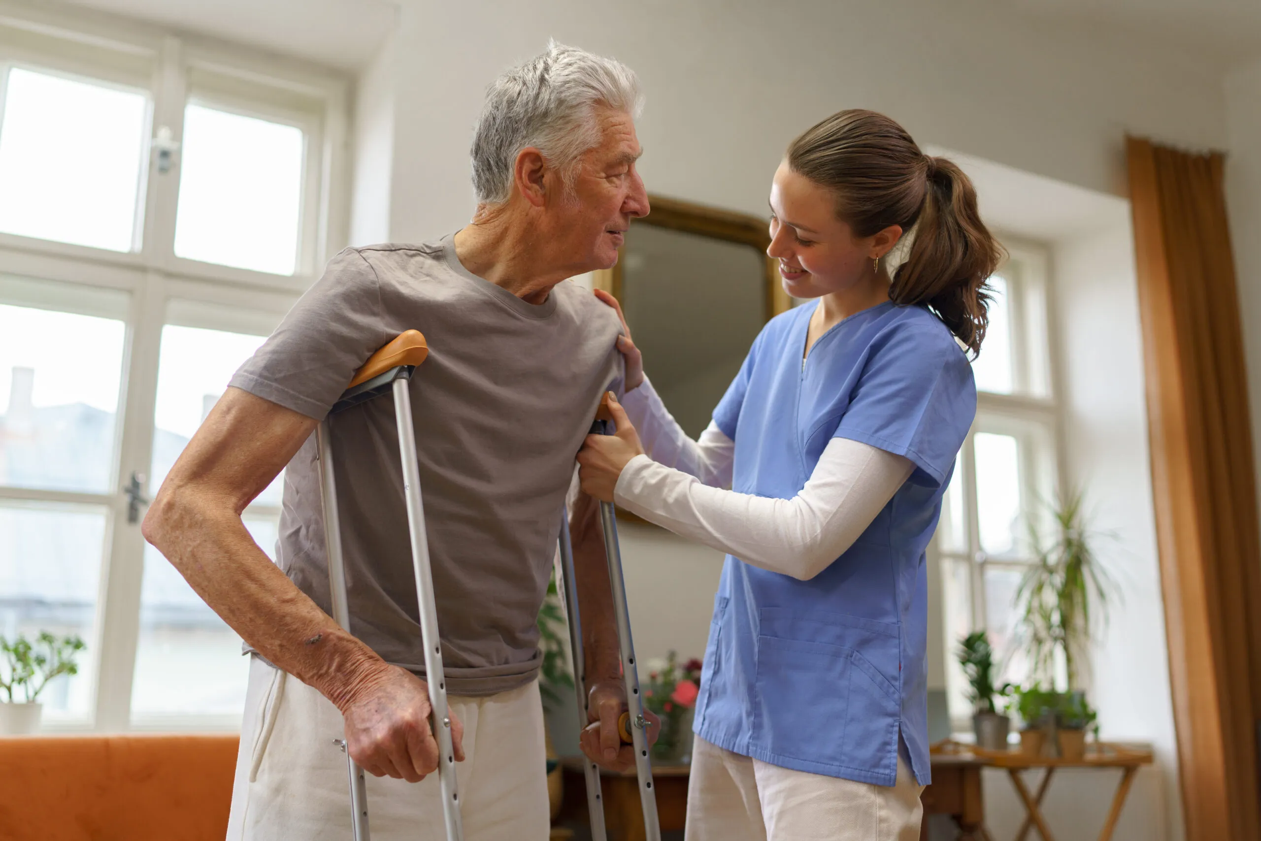 Young nurse helping senior man with walking. Compassionate post-surgical home care in King City – expert post operative caregivers supporting safe recovery at home.