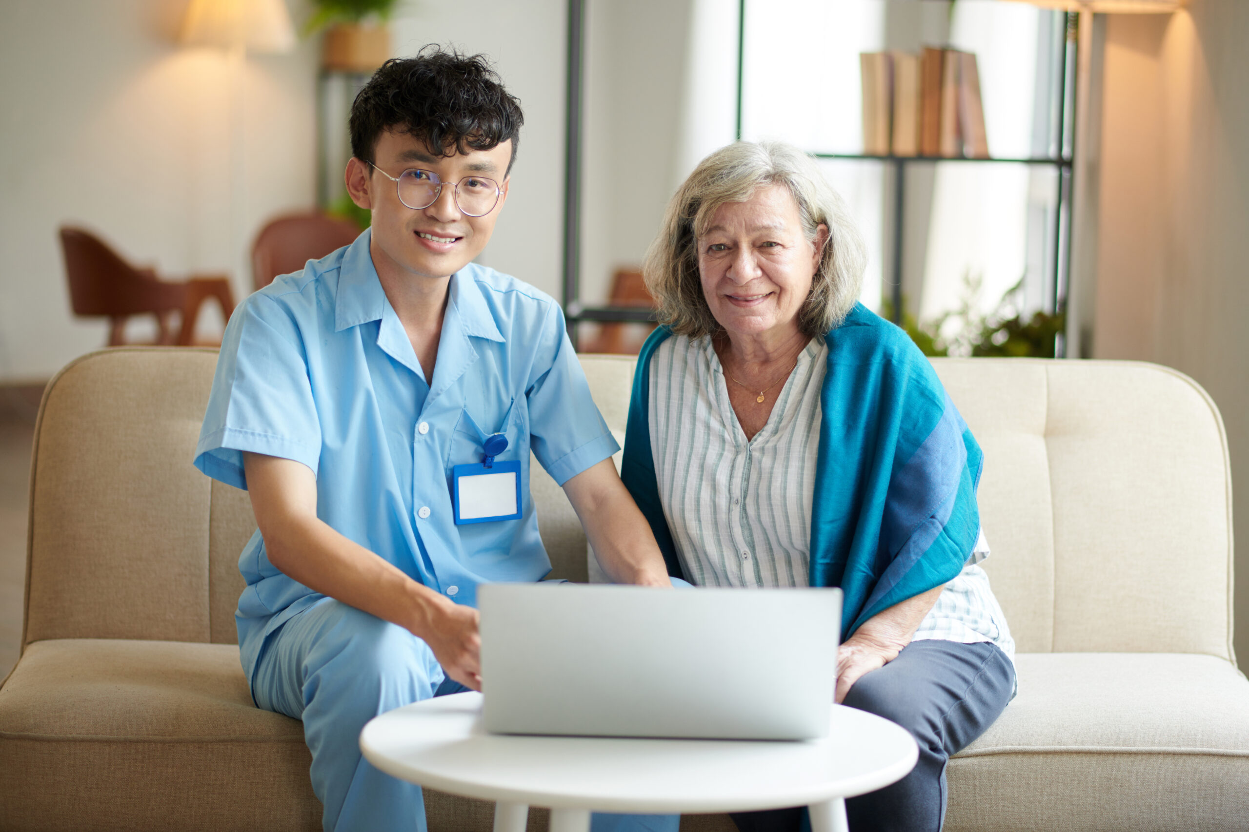 Caregiver Teaching Senior Woman Video Calling Personal care aide in King assisting a senior with in-home personal care in a warm and supportive environment.